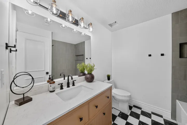 Bathroom featuring a light wood-finish vanity with a white countertop and integrated sink