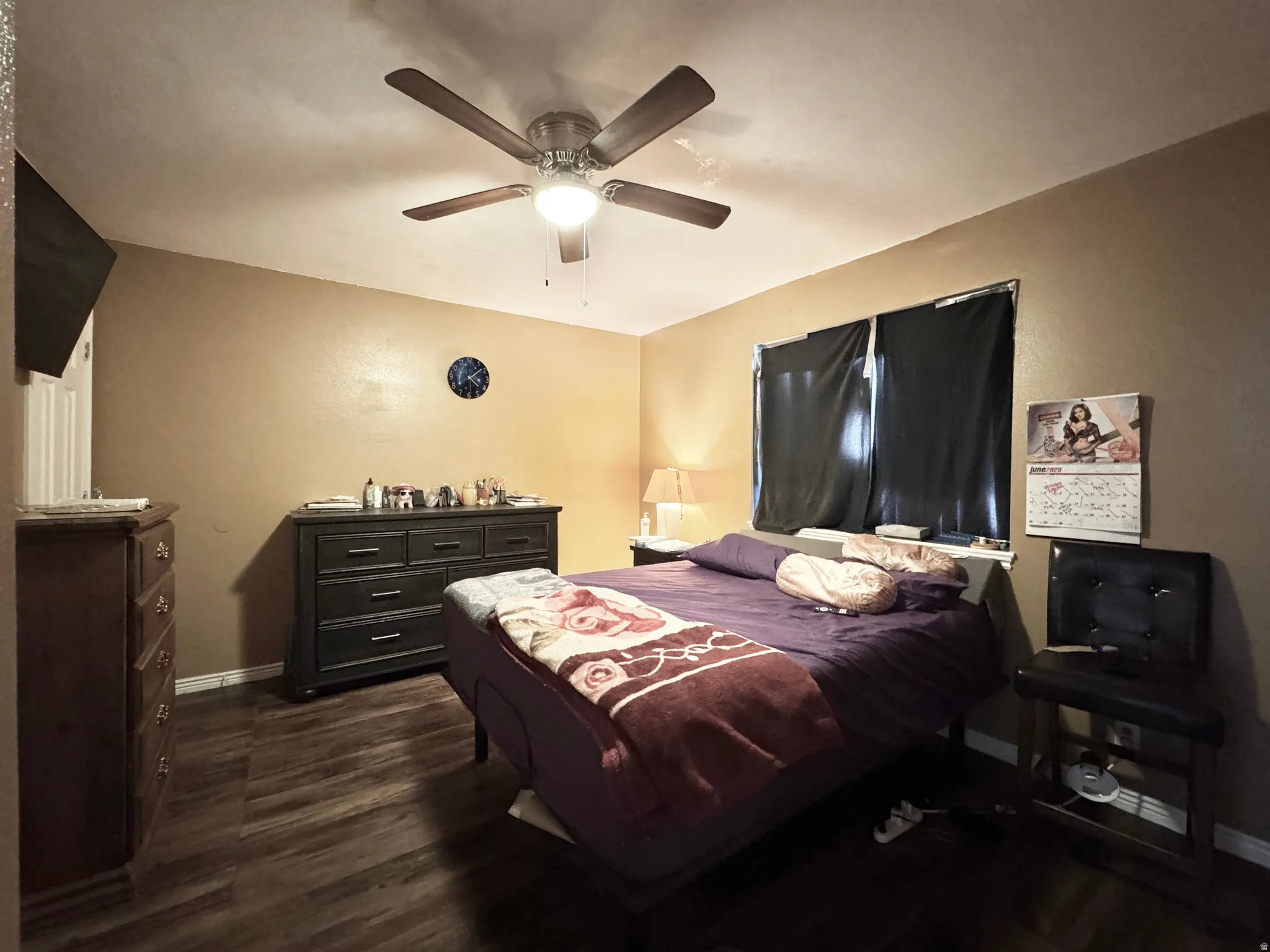 Wood-finish flooring anchors this room, complemented by a ceiling fan with integrated lighting