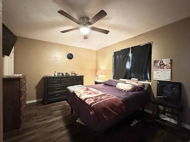 Wood-finish flooring anchors this room, complemented by a ceiling fan with integrated lighting