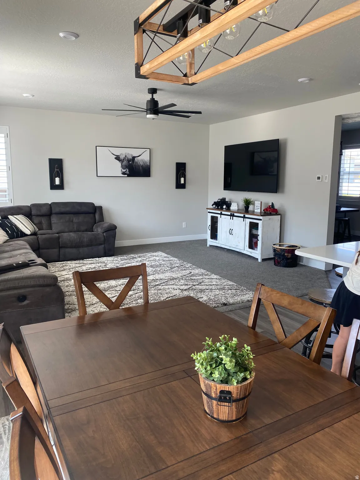 Open-concept living area featuring a wood-finish dining table and coordinated dining chairs