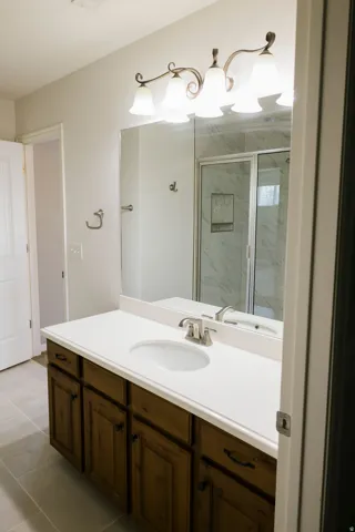 Bathroom featuring a wide vanity with a solid surface countertop, integrated sink, and wood-finish cabinetry