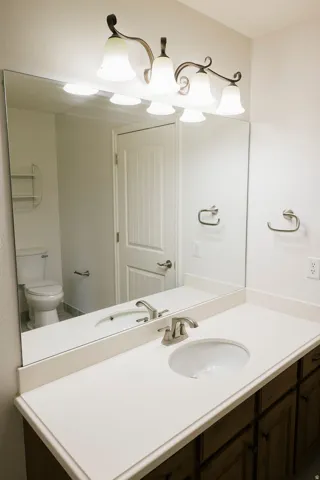 Bathroom vanity featuring an integrated sink, brushed nickel faucet, and a spacious countertop