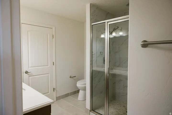 Walk-in shower with clear glass enclosure, a built-in bench, and tile surround