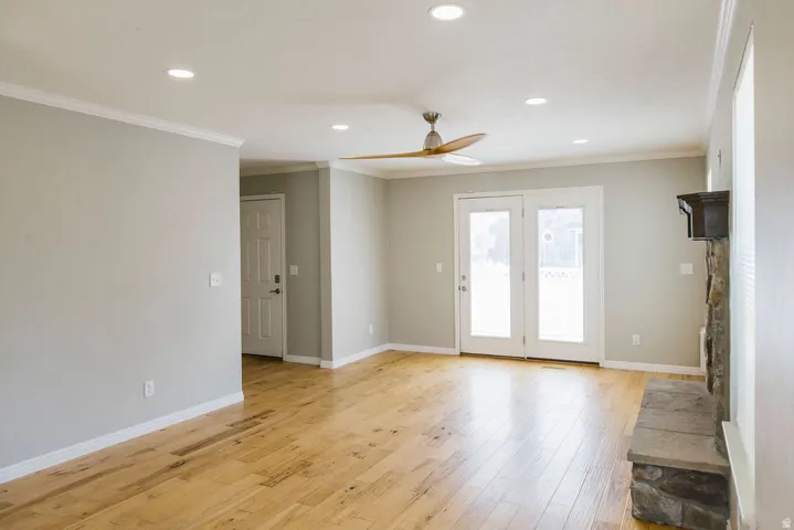 Living area featuring wood-finish flooring, recessed lighting, and crown molding