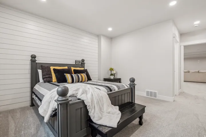 Bedroom featuring a shiplap accent wall, light gray carpeting, recessed lighting, and white trim