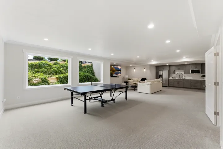 Spacious recreation room featuring carpet flooring, recessed lighting, and white trim