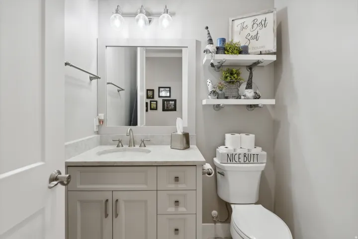 Bathroom featuring a single vanity with light grey cabinetry, a light-toned countertop, and a rectangular sink with a brushed nickel faucet