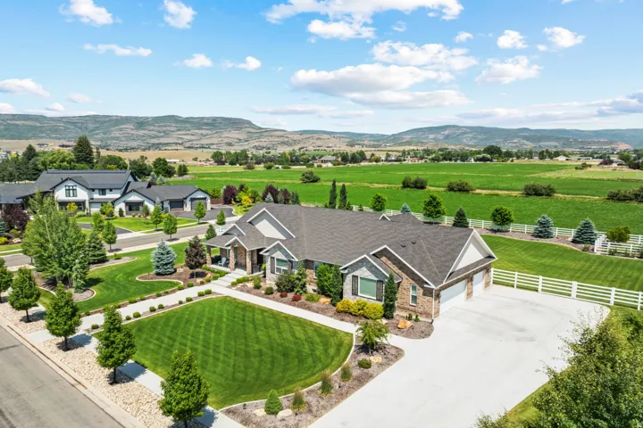 Ranch-style residence featuring stone and siding exterior, an attached multi-car garage, and a concrete driveway
