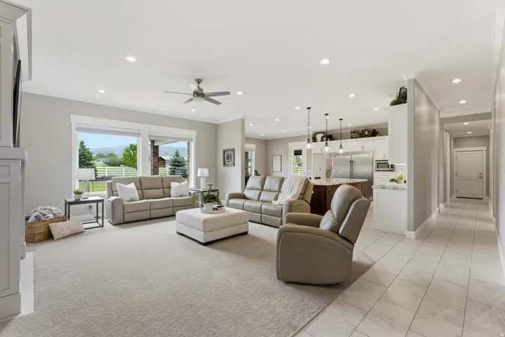 Spacious open-concept living area featuring a light-colored carpeted section and tile flooring