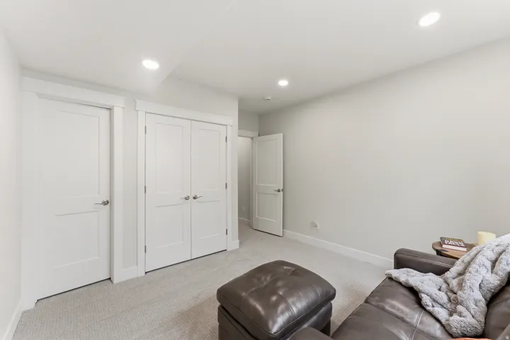 Light gray wall color with recessed lighting, white trim, and light-colored carpet flooring