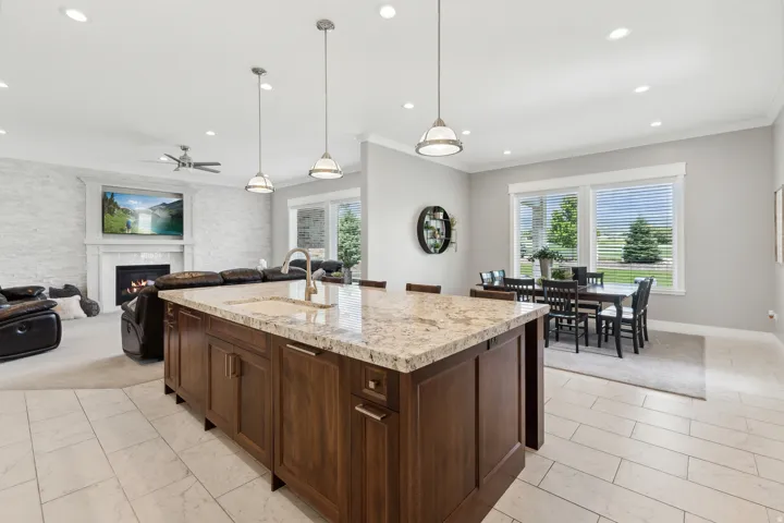 Spacious open-concept interior featuring a large kitchen island with a light-toned countertop, a built-in sink, and pendant lighting
