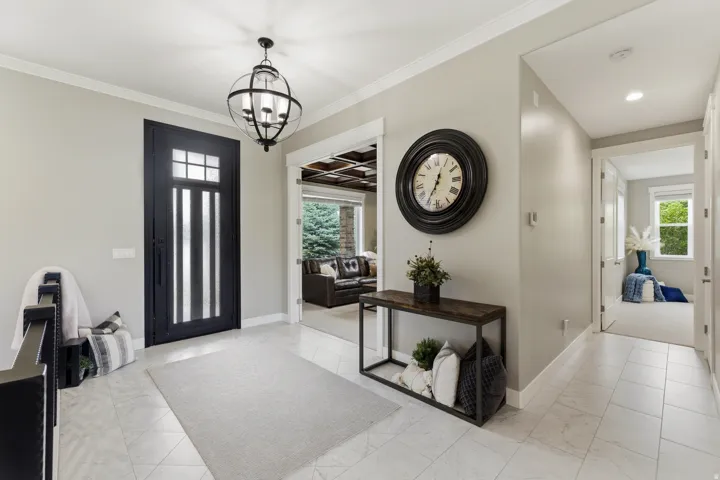 Entryway featuring light-toned tile flooring and a dark-framed glass-paneled entry door