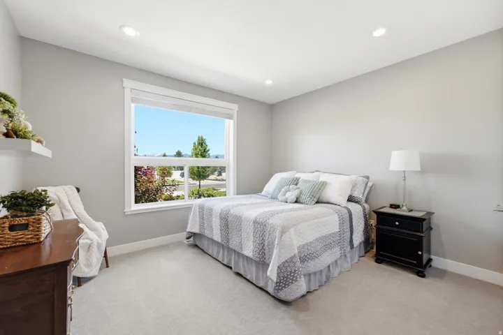 Carpeted bedroom featuring a large window, recessed lighting, and light gray wall paint