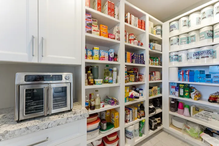Custom built-in pantry shelving provides extensive storage capacity