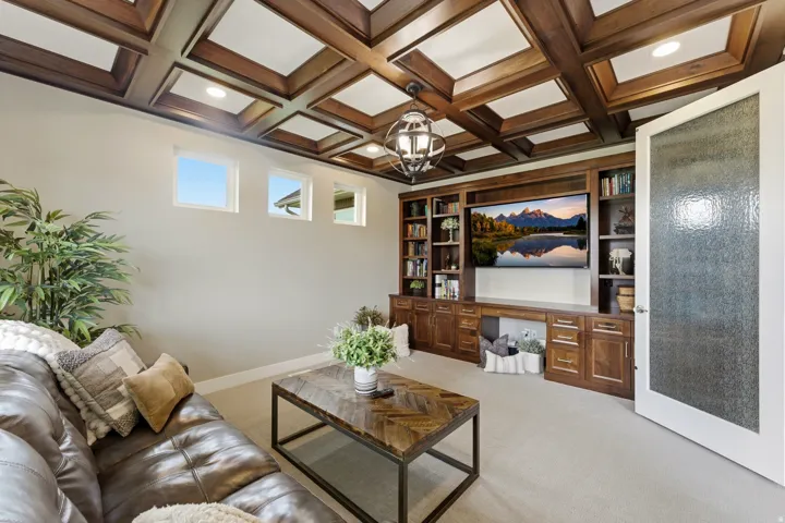 Coffered wood ceiling with recessed lighting and a central decorative fixture