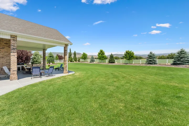 Expansive green lawn bordering a covered patio with brick columns