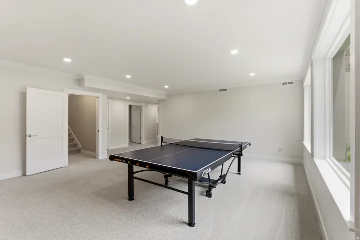 Spacious room featuring light-toned carpeting, recessed ceiling lighting, and crisp white trimwork
