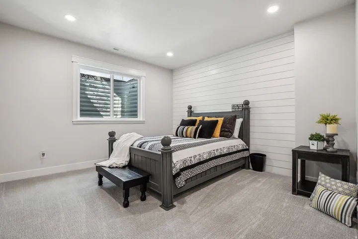 Neutral wall paint, recessed lighting, and light grey carpeting provide a bright interior