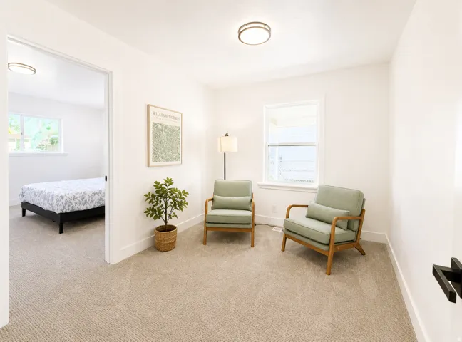 Carpeted room with white walls, a flush-mount ceiling light, and a framed window