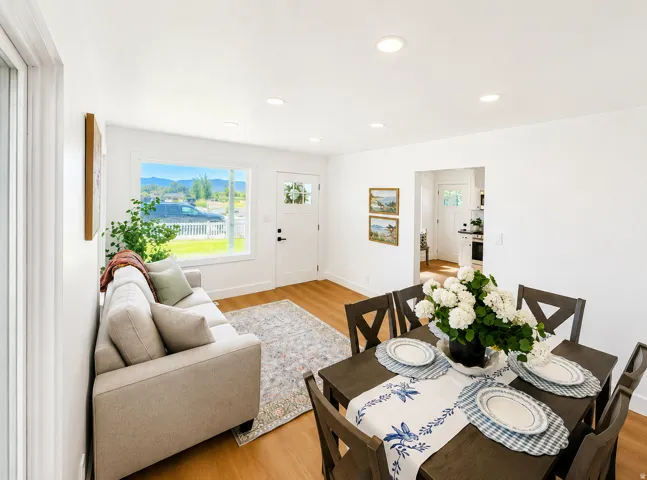 Open concept living and dining area featuring wood-finish flooring, recessed lighting, and a front entry door with decorative glass