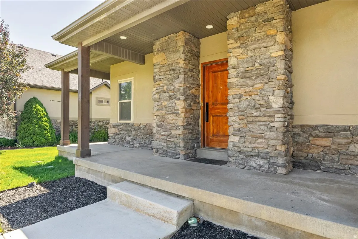 Stone facade entry with a solid wood front door
