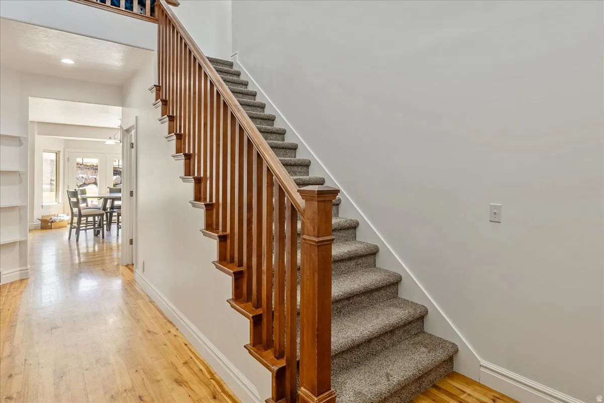 Staircase featuring wood balusters and a carpeted tread