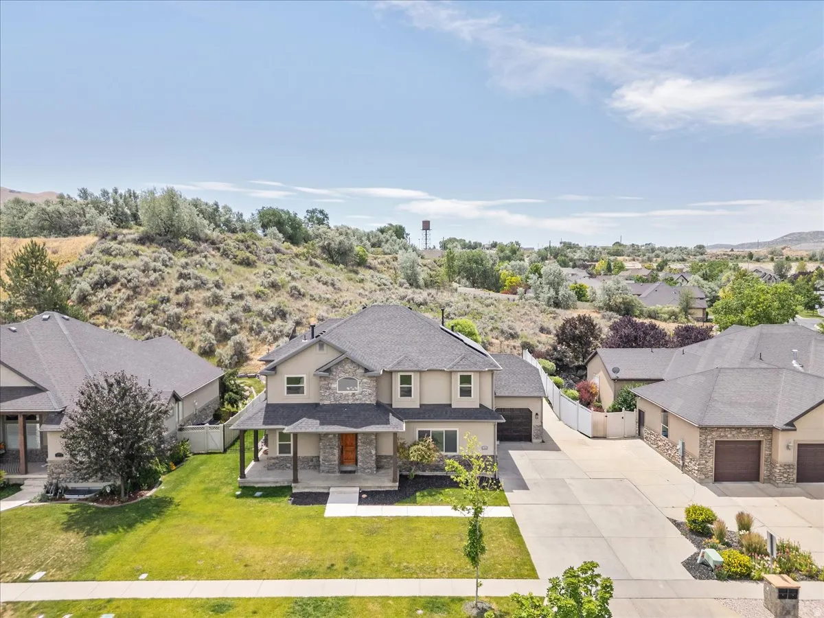 Two-story residence featuring stone and stucco exterior, covered front porch, and an attached two-car garage