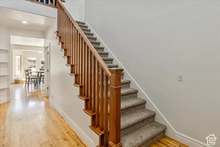 Staircase featuring wood balusters and a carpeted tread