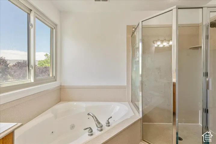 Soaking tub with chrome fixtures, surrounded by a light-colored countertop
