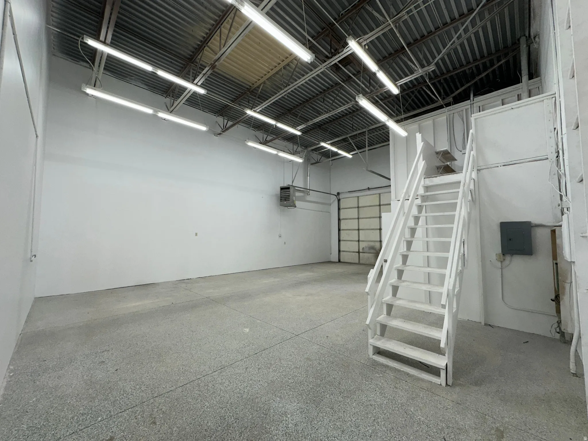 Spacious commercial interior featuring concrete flooring and white painted walls