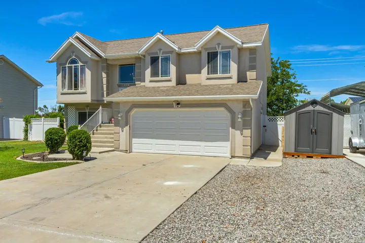 Two-story home with a two-car garage, concrete driveway, and dormer windows