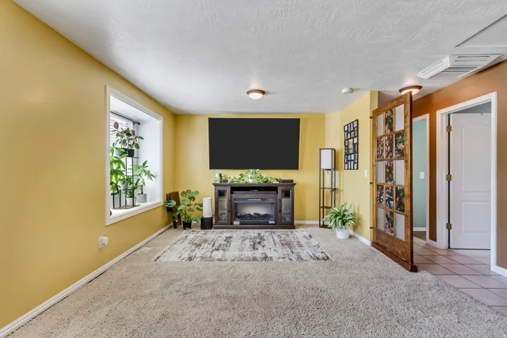 Living area featuring a built-in entertainment center with a fireplace insert, a recessed window, and wall-mounted lighting