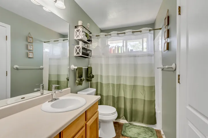 Bathroom featuring a single vanity with an integrated sink, a rectangular mirror, and an overhead light fixture