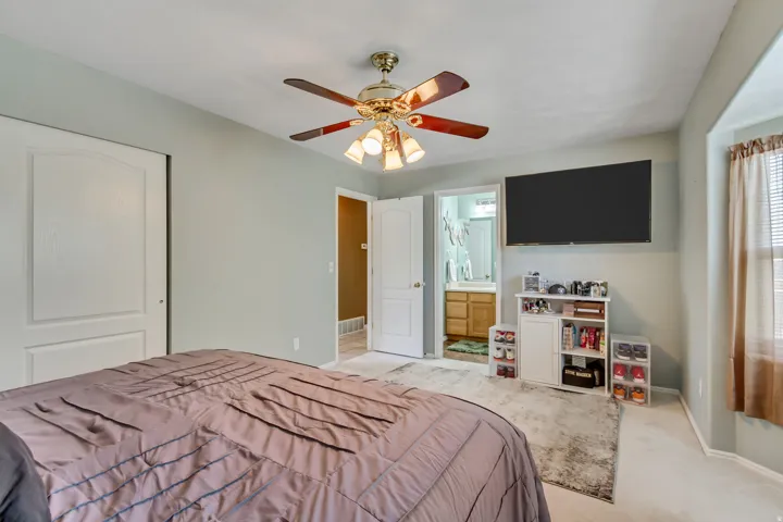 Bedroom featuring light gray wall paint, white trim, and light beige carpet