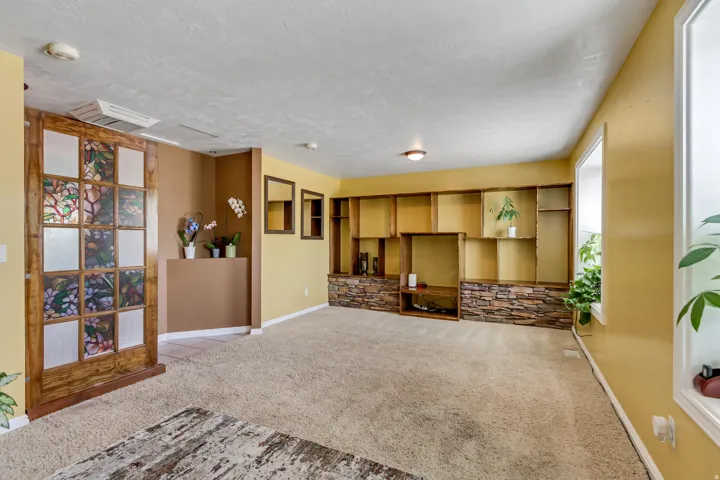 Spacious room featuring a decorative wooden sliding door with patterned glass inserts