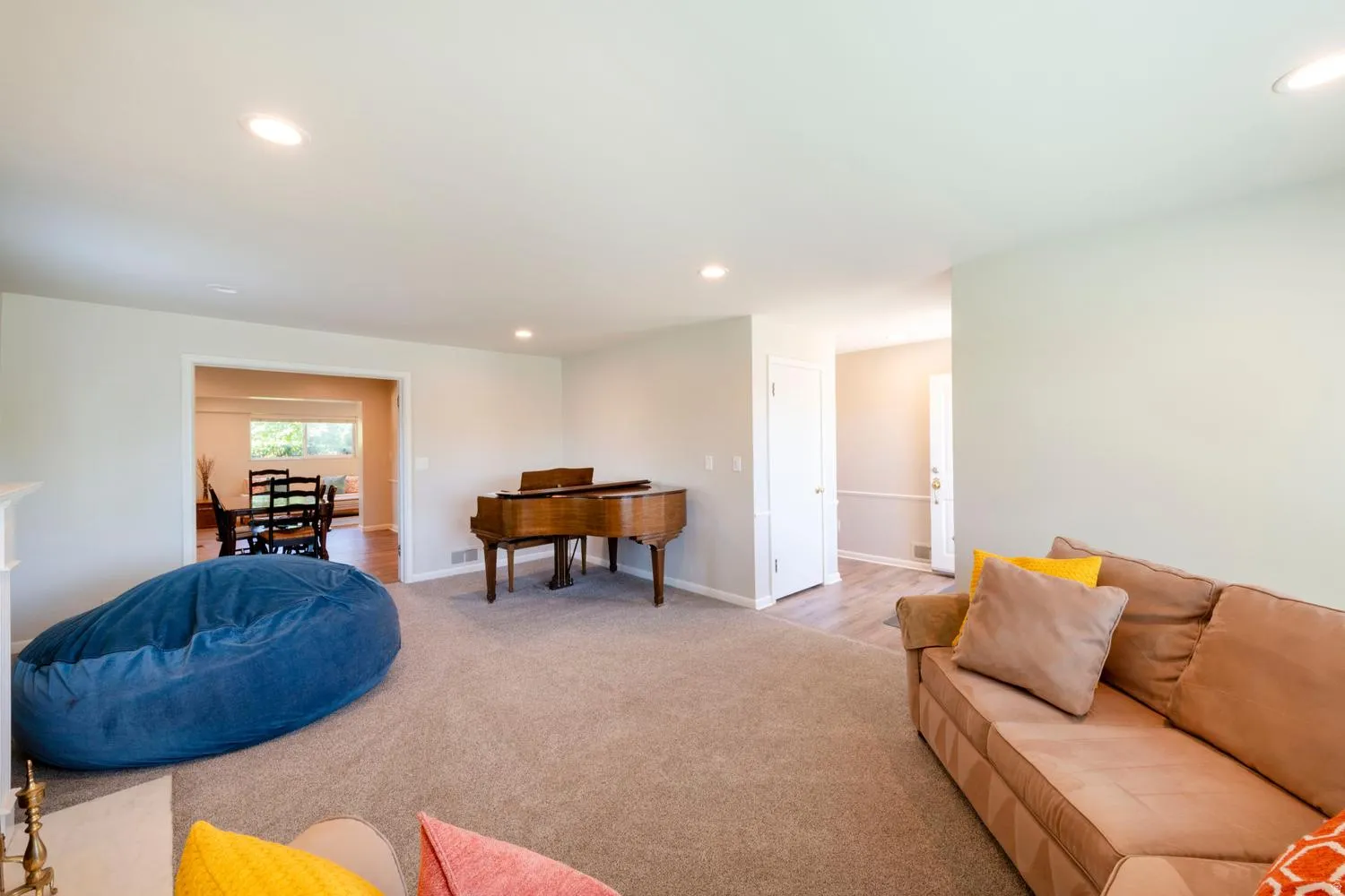 Spacious living area featuring neutral carpeting and recessed lighting
