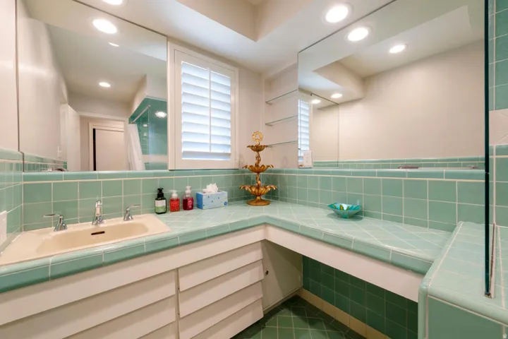 Bathroom featuring an integrated vanity with a tiled countertop and basin sink
