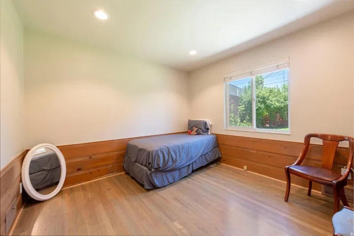 Room featuring wood-finish flooring, recessed lighting, and a window with white blinds