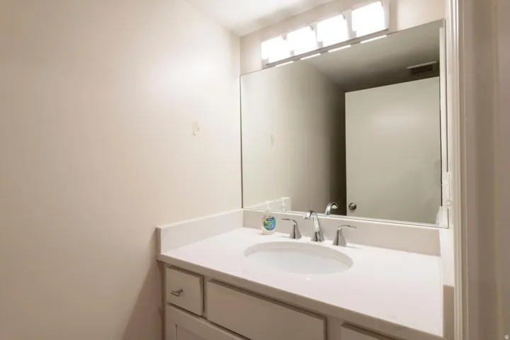 Remodeled 3/4 bathroom vanity featuring a white countertop with an integrated sink and chrome faucet