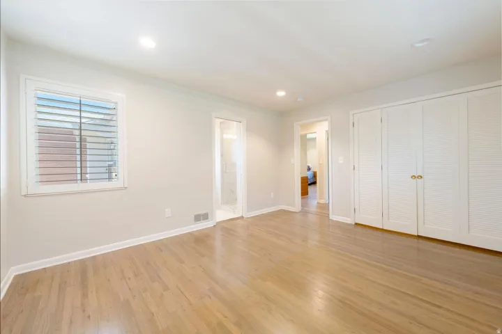 Spacious interior featuring wood-finish flooring, recessed lighting, and white walls