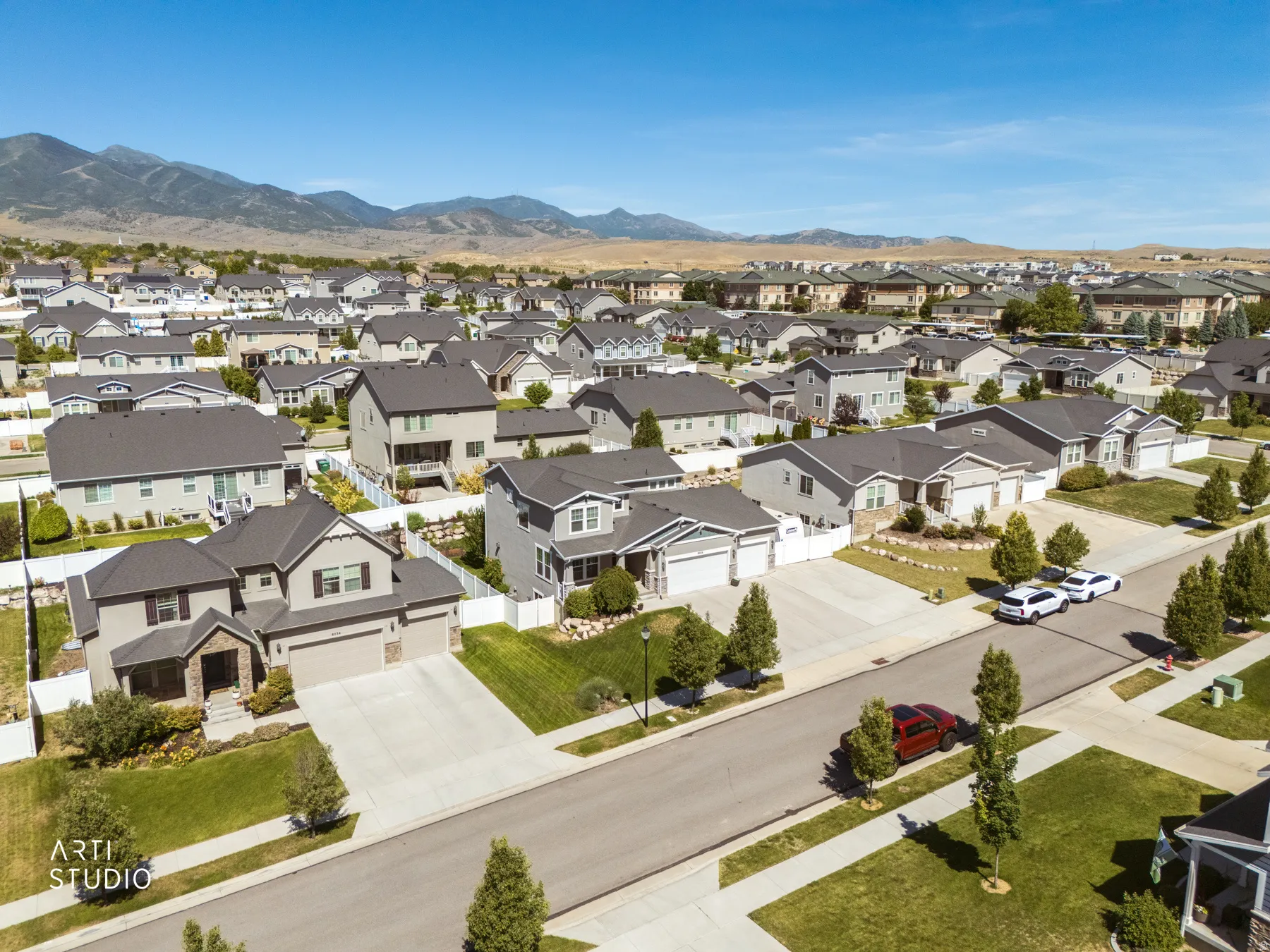 Residential neighborhood with varied home styles, concrete driveways, and manicured lawns