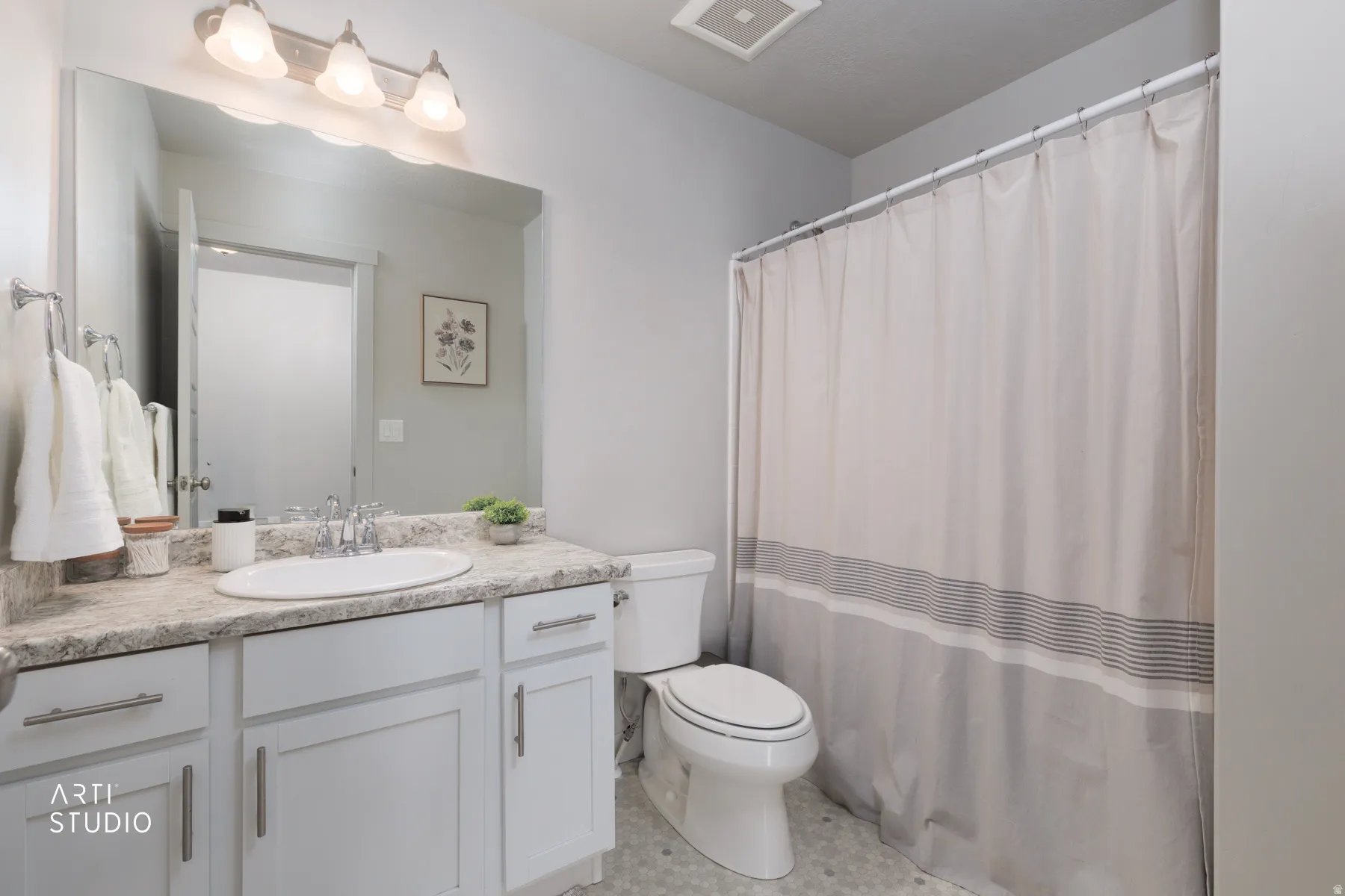Bathroom featuring a vanity with a white oval sink, stone-finish countertop, and brushed nickel faucet