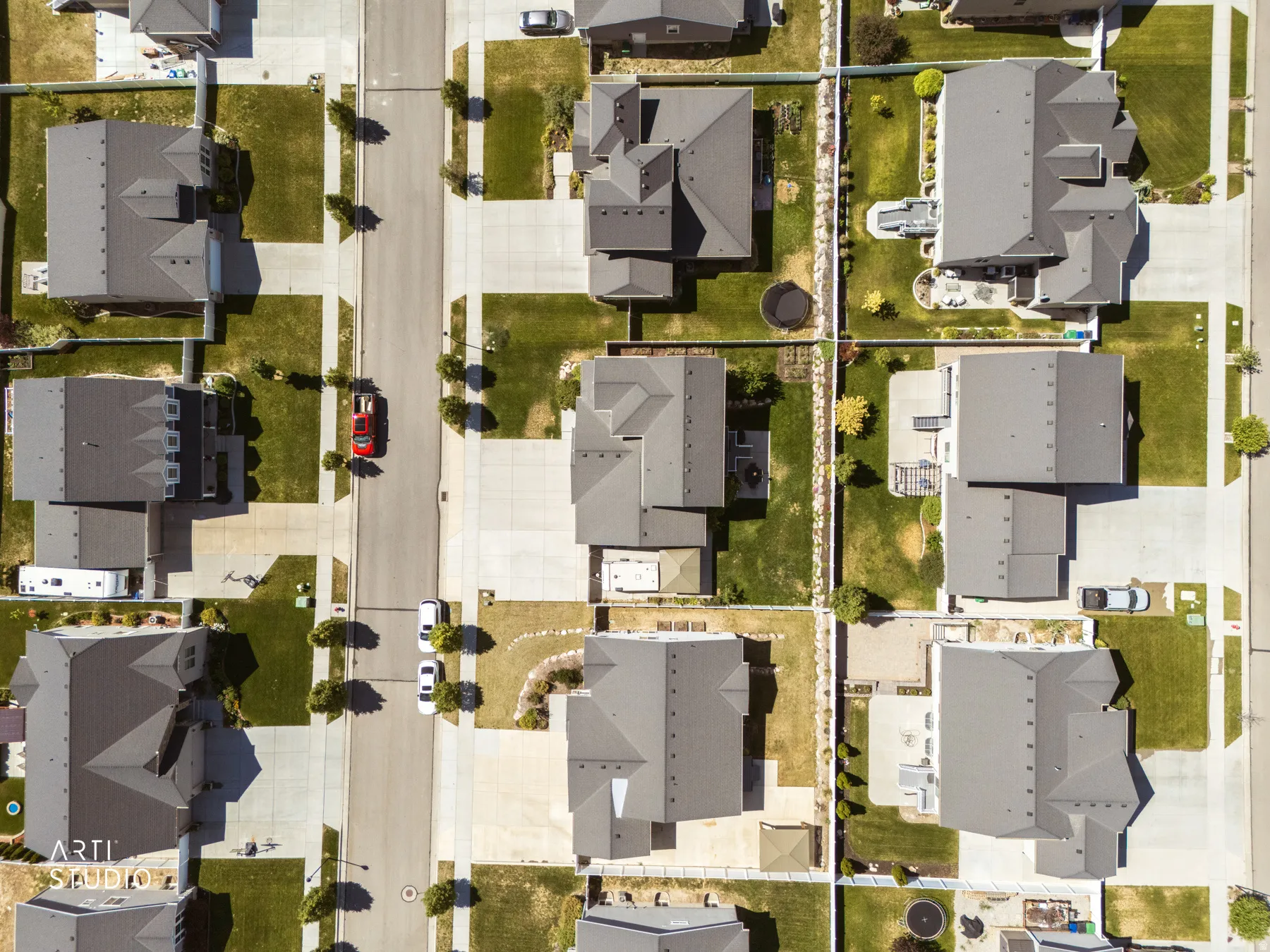 Aerial perspective showcasing a residential neighborhood with uniformly designed homes featuring dark gray roofs