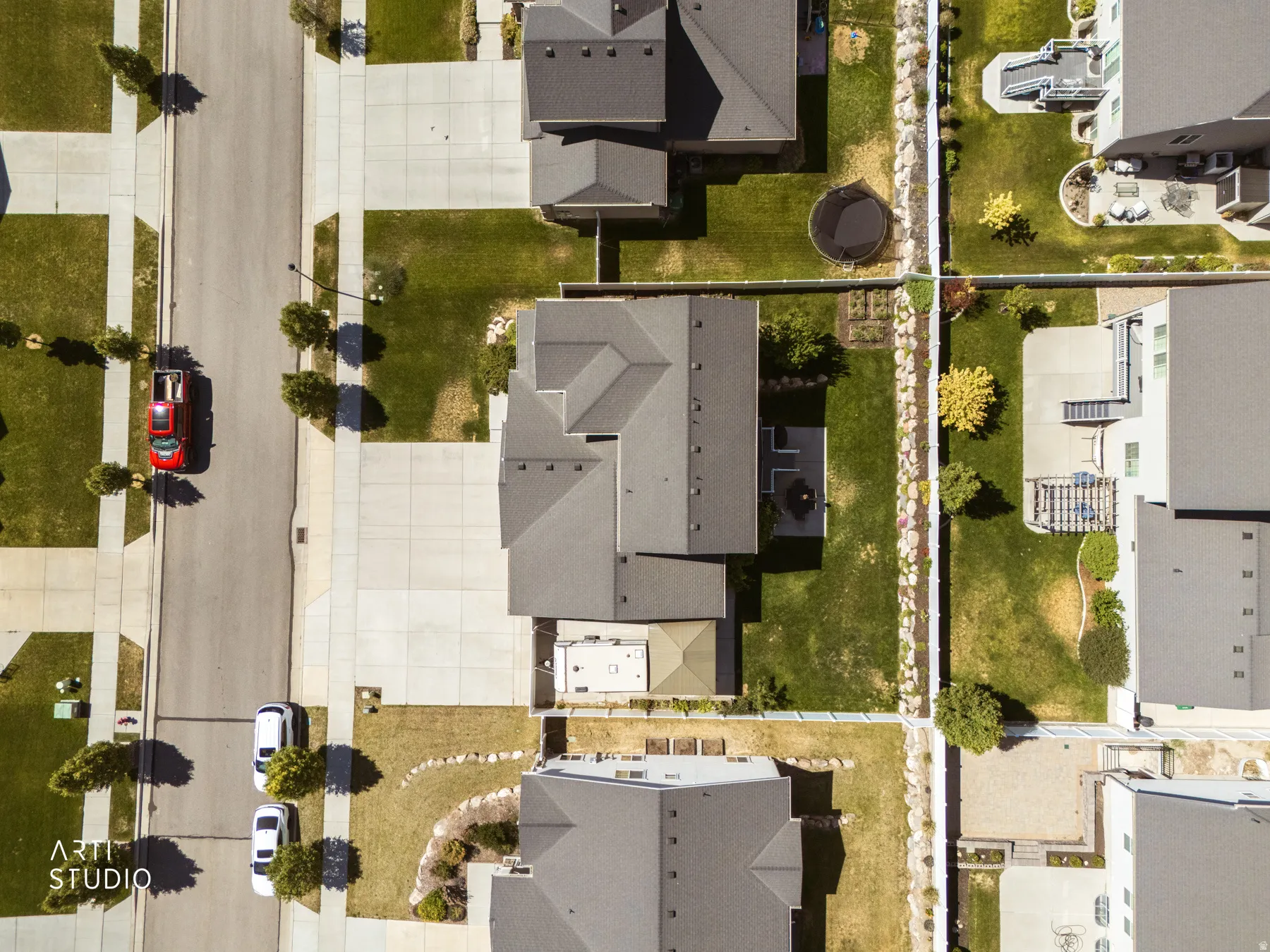 Overhead perspective showcasing a residential property with a dark shingle roof and a concrete driveway