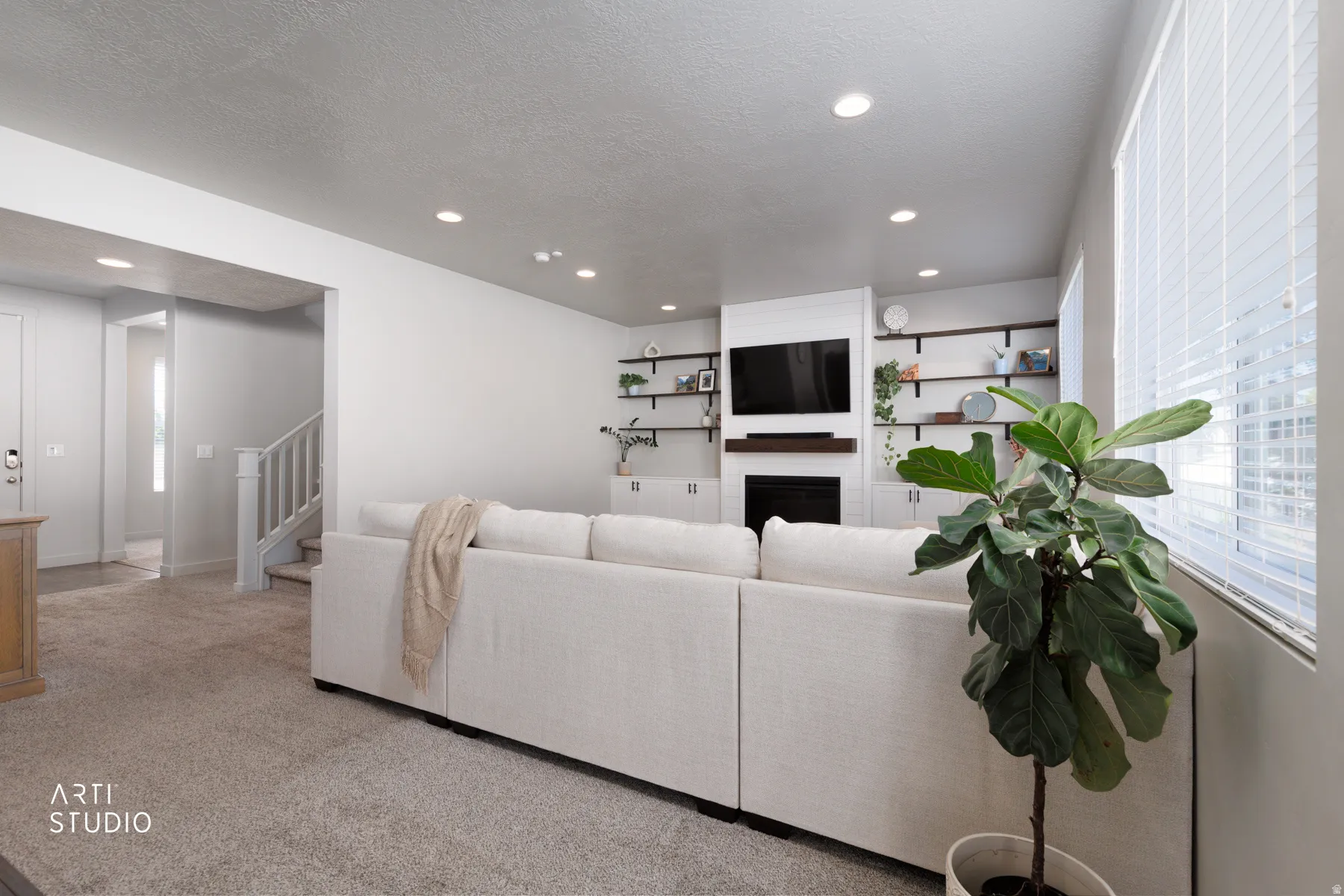Living area featuring recessed lighting, a built-in fireplace with a wood mantle, and integrated shelving