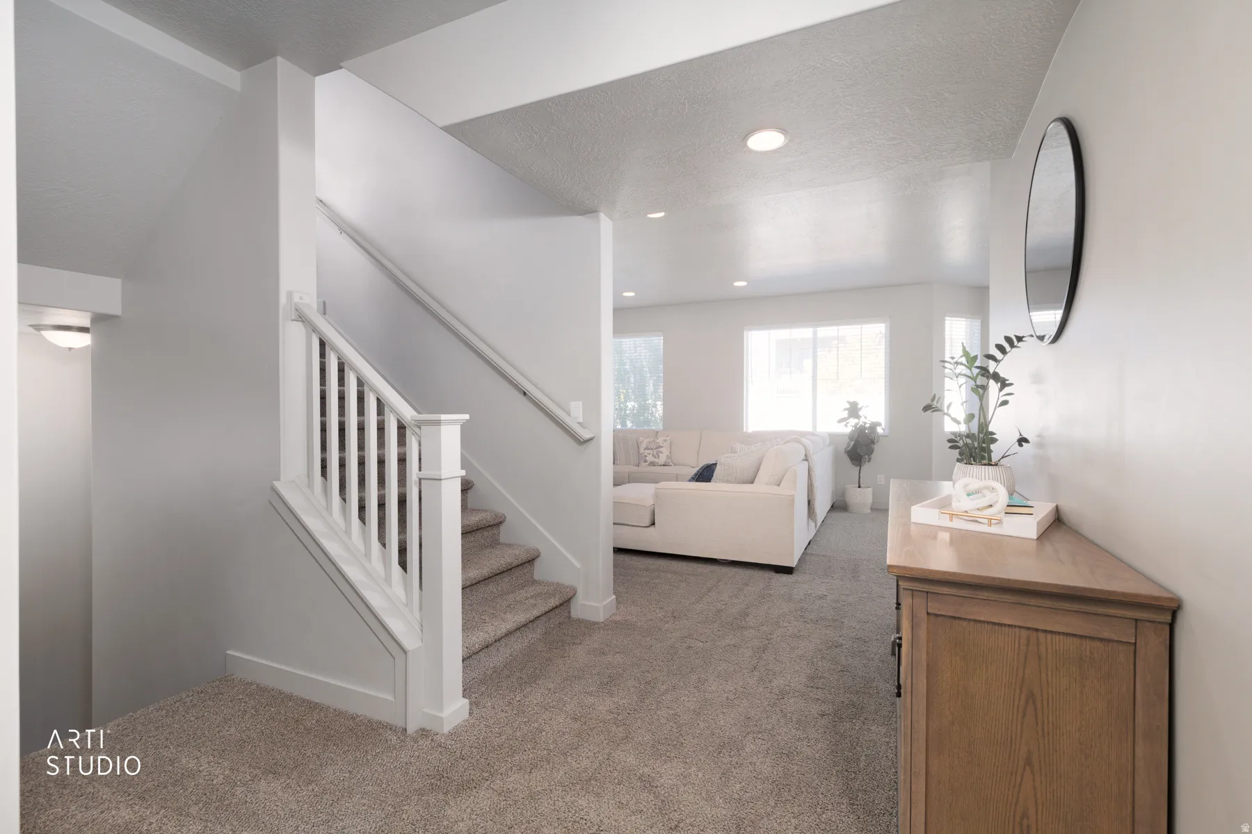 Carpeted staircase with white balusters and handrails