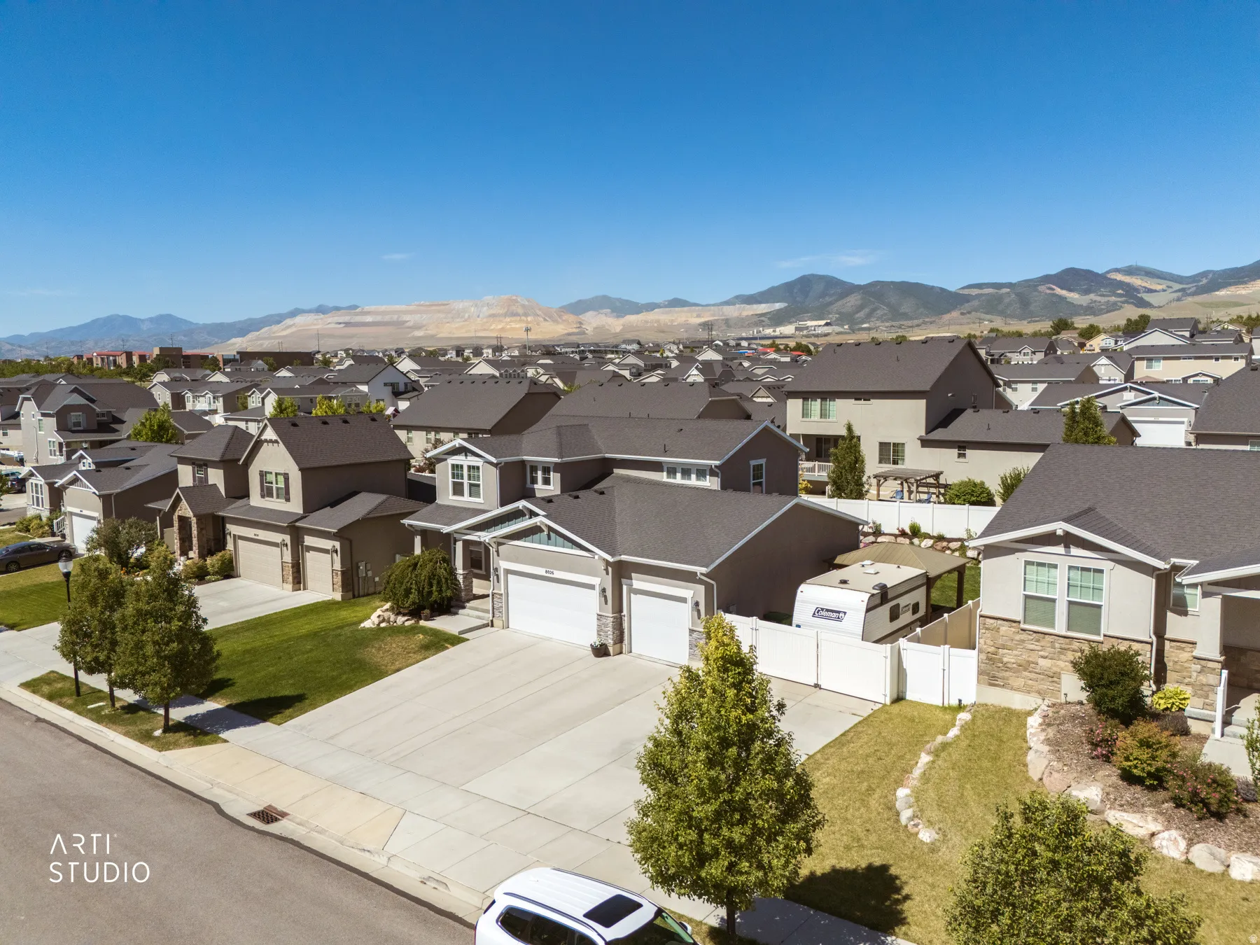 Contemporary residential property with a two-car garage, concrete driveway, and established front landscaping