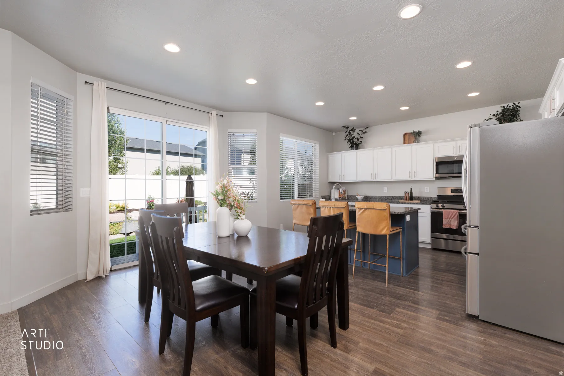 Open-concept living space featuring wood-finish flooring, recessed lighting, and a sliding glass door to the exterior