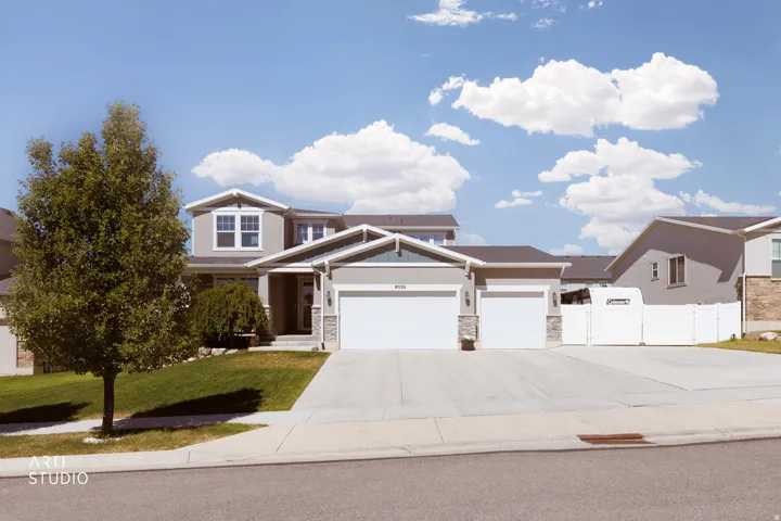 Two-story residence featuring a gray exterior with white trim accents and a dark-shingle roof