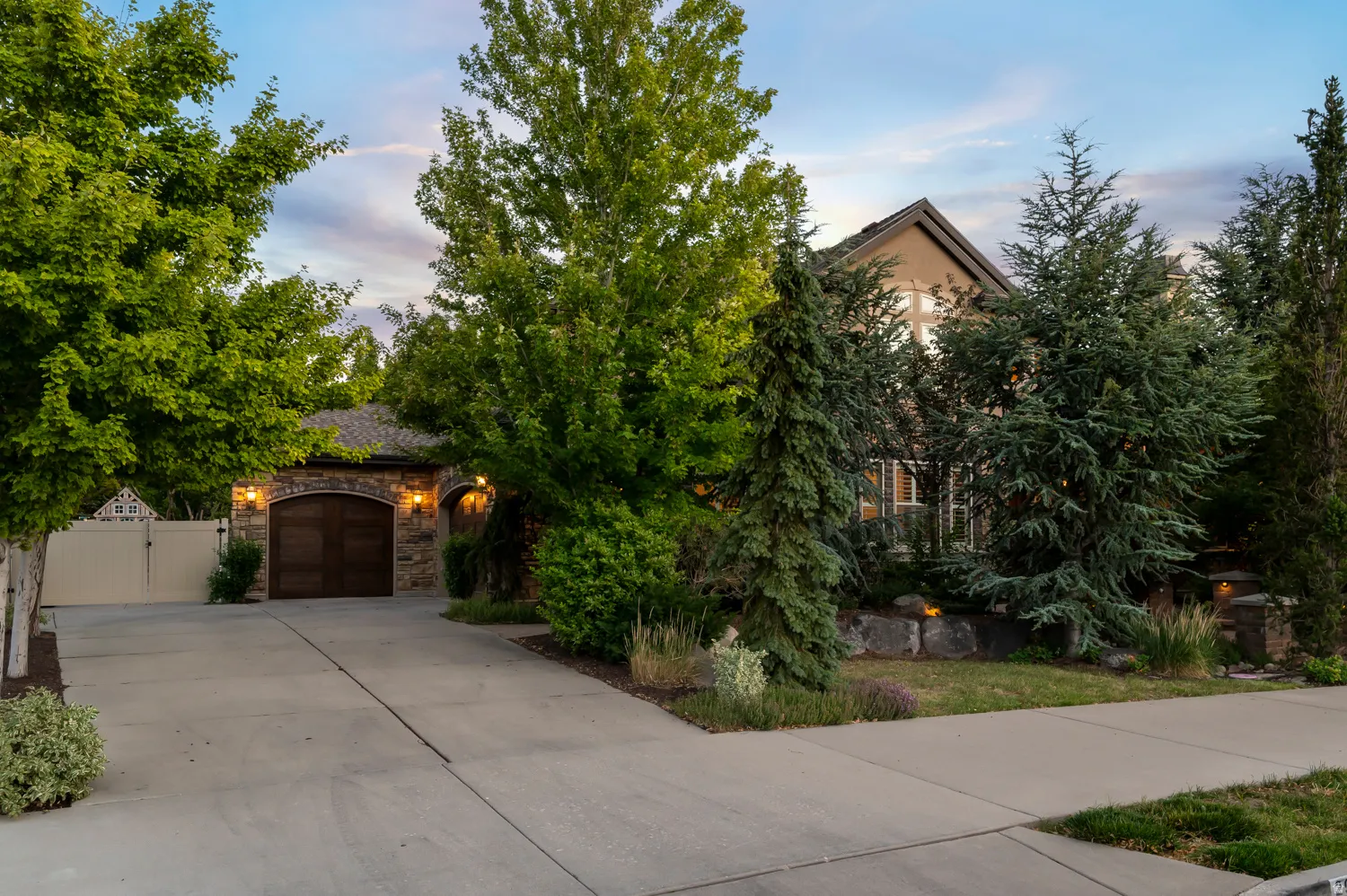 Stone and stucco exterior with a wood-finish garage door